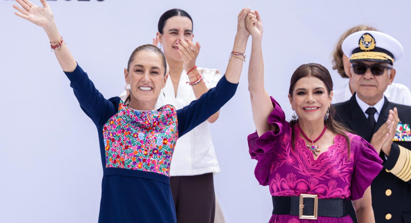 Claudia Sheinbaum y Clara Brugada sonríen con las manos unidas y los brazos levantados durante el acto en el Zócalo.